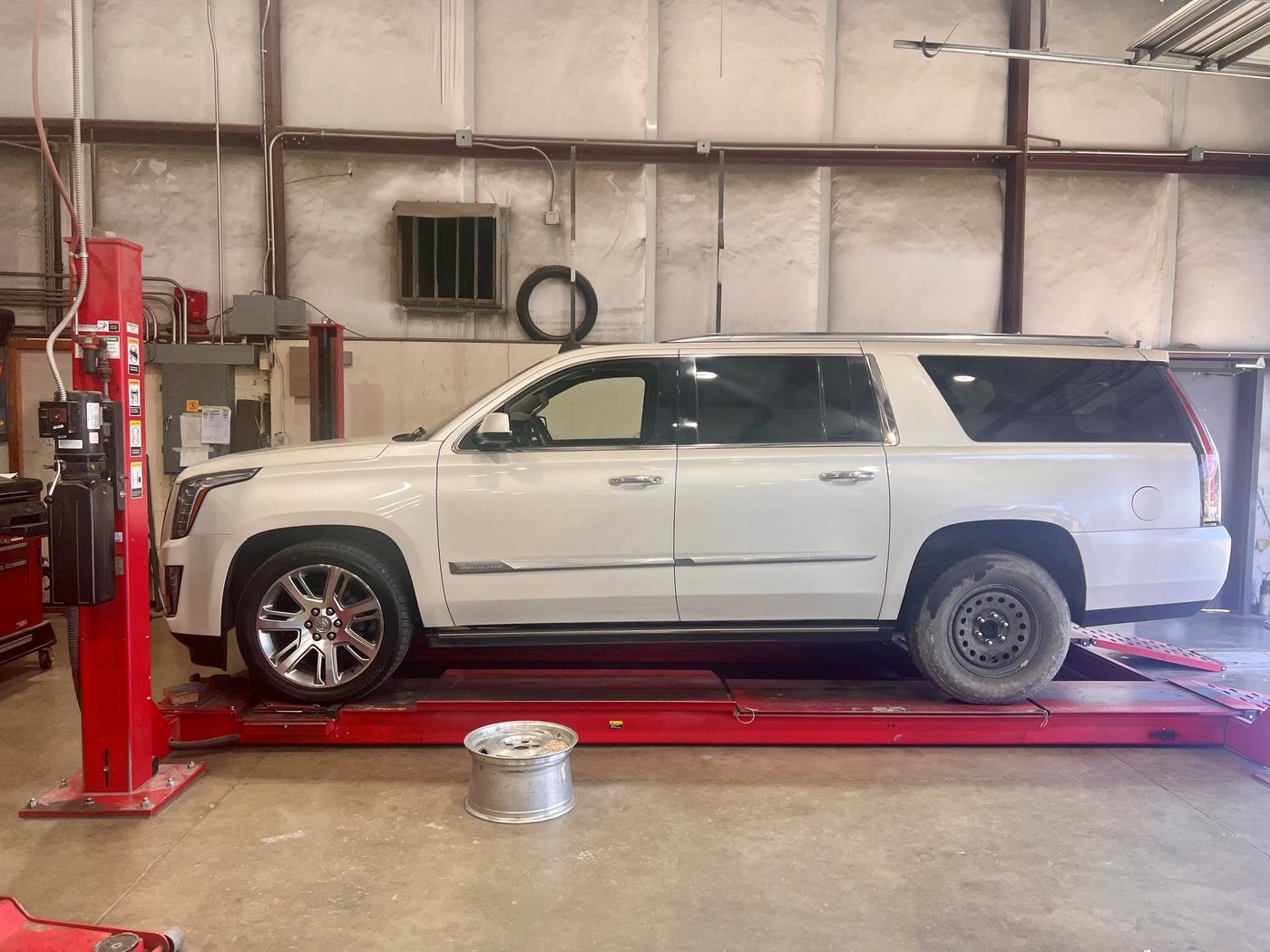 White Cadillac Escalade ESV on the frame-straightening machine inside Bertolucci's shop in Sacramento