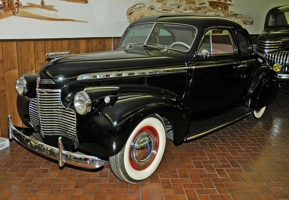 Black 1940 Chevrolet Special Deluxe Club Coupe with chrome grille and whitewall tires with red pinstripes