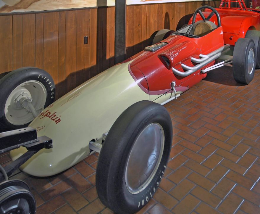 Cream and red 1954 vintage dragster named The Dolphin, with chrome exhaust pipes and Firestone tires