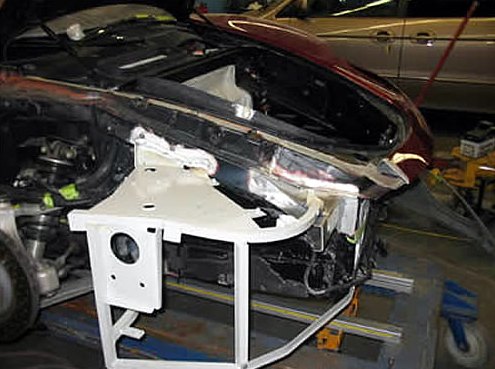 Step 4: White structural repair fixture bolted to the Ferrari's front structure on the frame bench