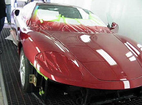Step 10: Ferrari front end freshly painted glossy red inside the paint booth with masking still in place